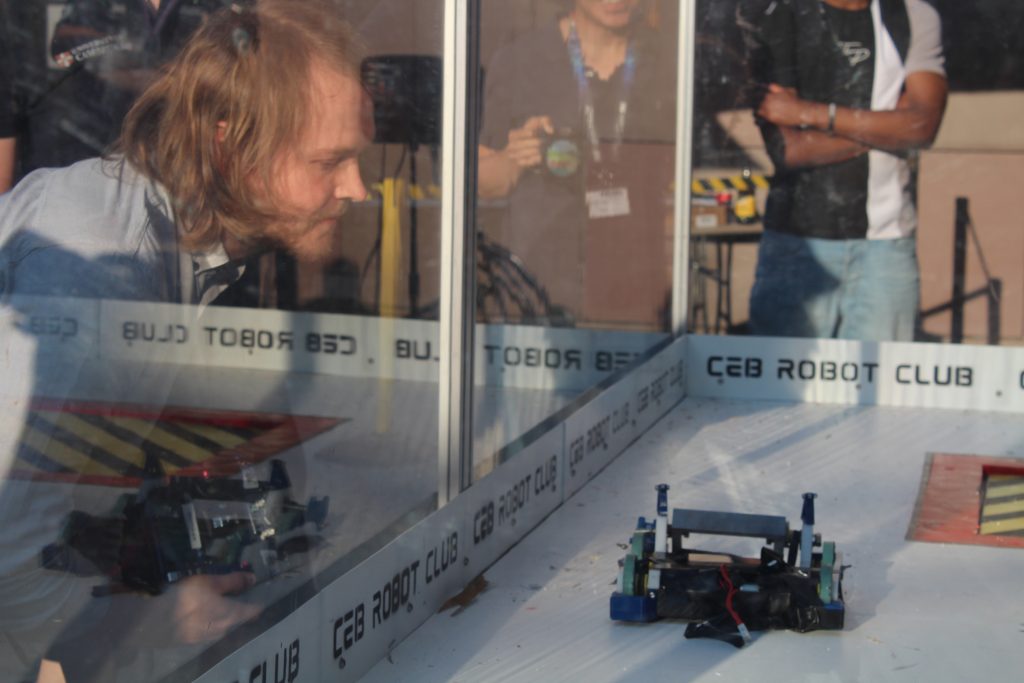 Senior research associate Edward Ward looking at his robot through a perspex shield.